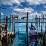Venezia tra cielo terso e riflessi: dialogo tra pali e barca nel porto del centro storico