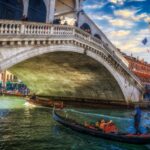 Venezia: riflessi, luce e architettura lungo il ponte verso l’edificio di quercia