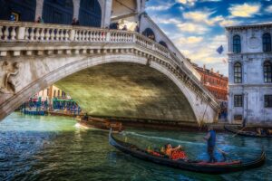 Venezia: riflessi, luce e architettura lungo il ponte verso l’edificio di quercia