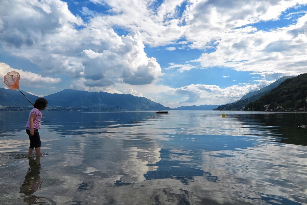 Cannero: calma, immaginazione e riflessi tra lago e montagne con una figura in primo piano