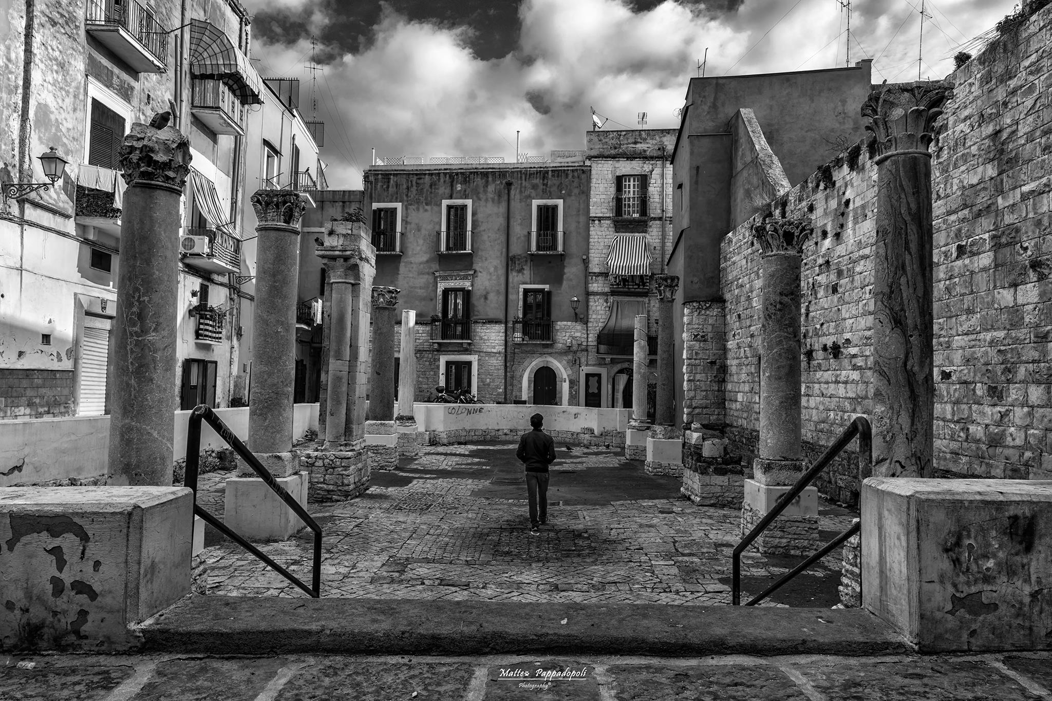 Contemporaneità monumentale: figura nel centro, architettura medievale in B/N