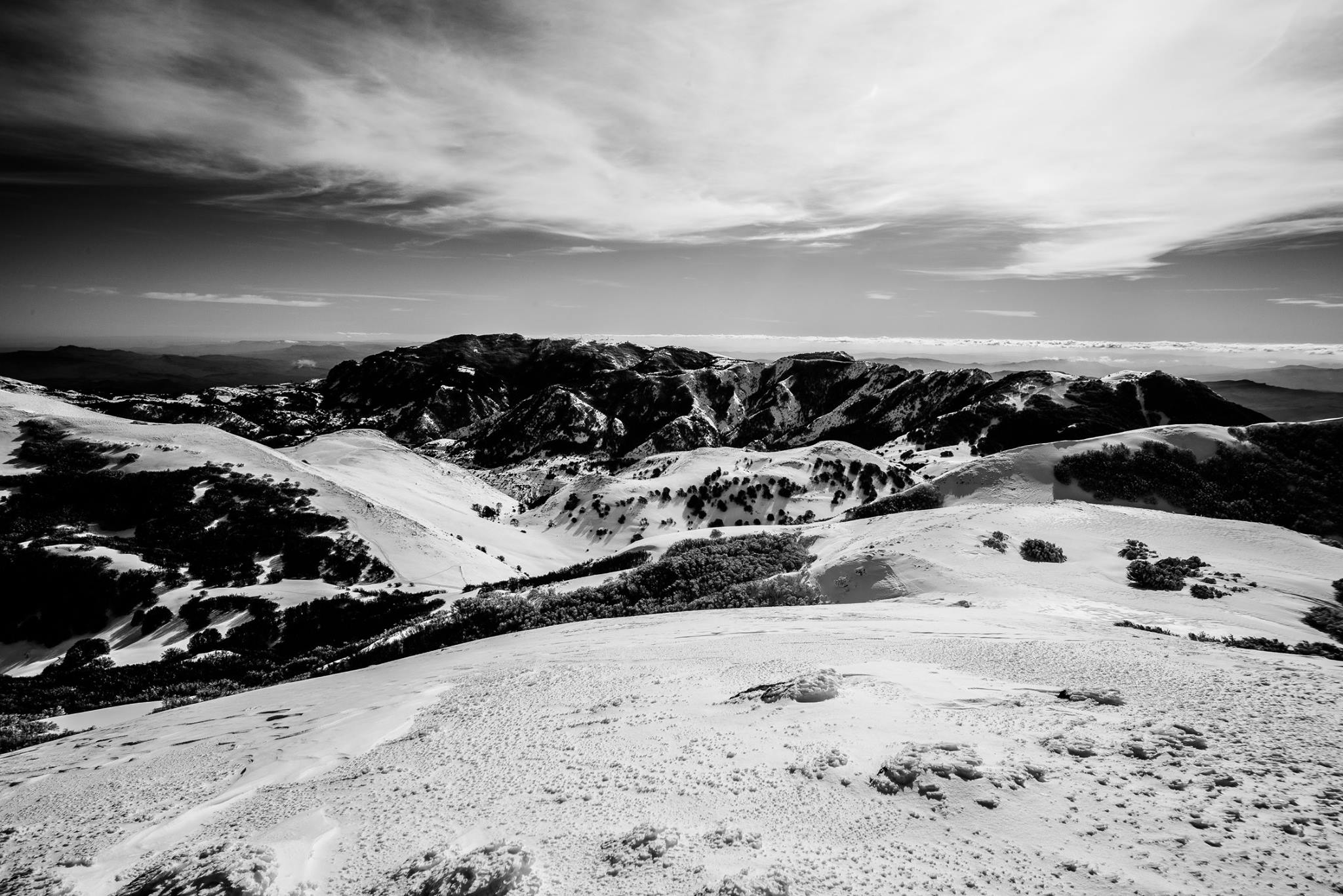 Bianco e nero: distesa nevosa, roccia centrale e profondità atmosferica