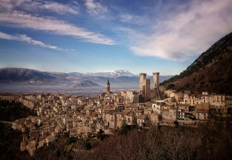 Borgo medievale tra case e torrioni, attenzione a profondità tra cielo e montagne