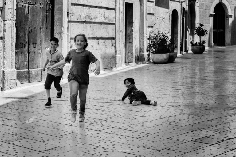 Spontaneità urbana in bianco e nero: volti, gesti e profondità tra pareti antiche