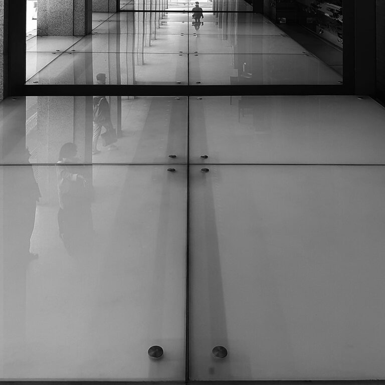 Riflessi e superfici: quiete geometria tra vetrate e figure in B/N