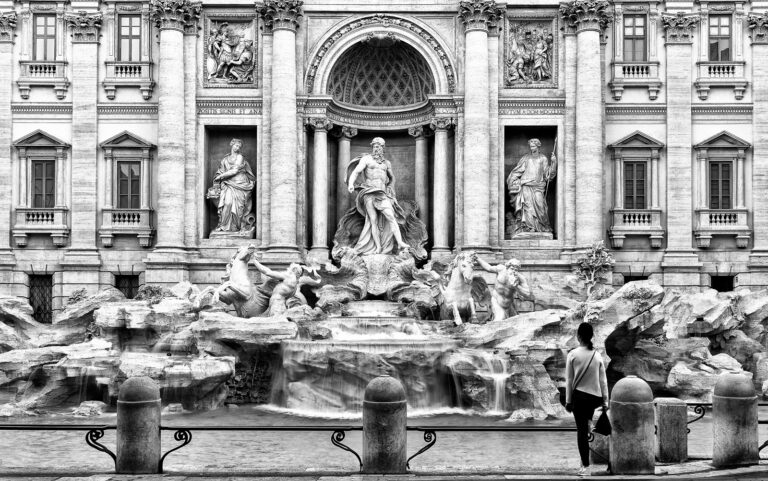 Monumentalità lenta: centralità della statua tra acqua, pietra e silenzio umano