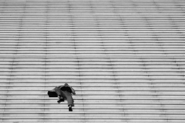 Solitudine ritmata: geometrie di scale, diagonali e luce diffusa sulla figura