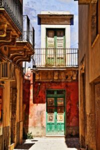 Entrata colorata tra geometrie di luce e tempo nel cortile urbano
