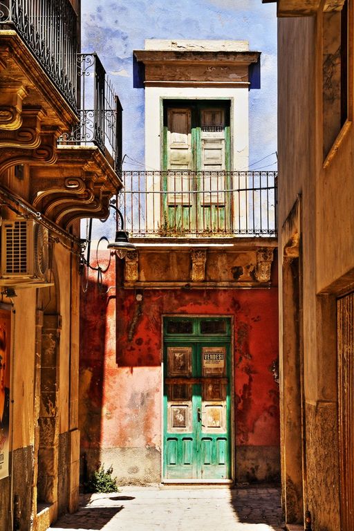 Entrata colorata tra geometrie di luce e tempo nel cortile urbano