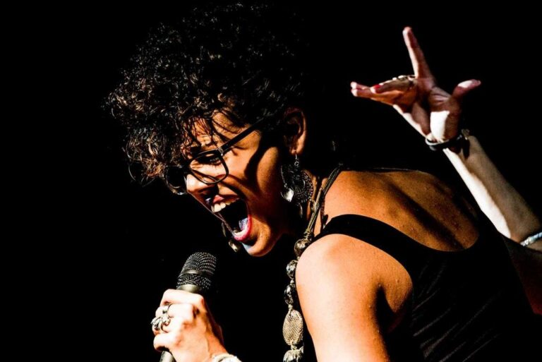 Potenza scenica e controllo del contrasto in un primo piano di cantante sul palco